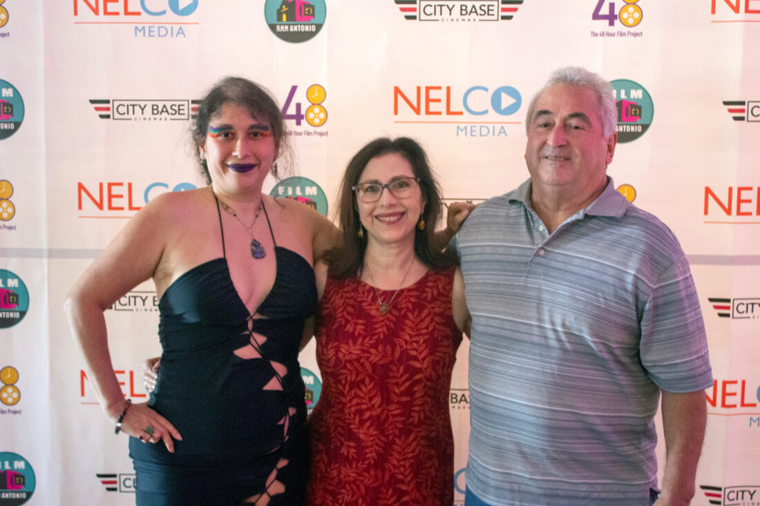 Ellice stands with her family at red carpet event, horizontal shot, no flash